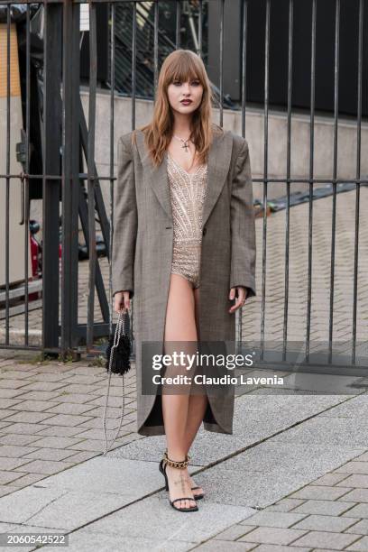 Victoria De Angelis wears nude decorated bodysuit, brown coat, black sandals, black Stella McCartney bag, outside Stella McCartney, during the...
