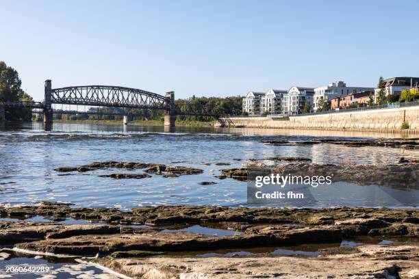 city of magdeburg at low tide - historic lift bridge at elbe river with residential buildings (magdeburg - saxony-anhalt/ germany) - magdeburg stock pictures, royalty-free photos & images