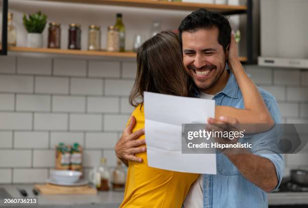 couple at home reading good news in a letter they got in the mail - responder imagens e fotografias de stock