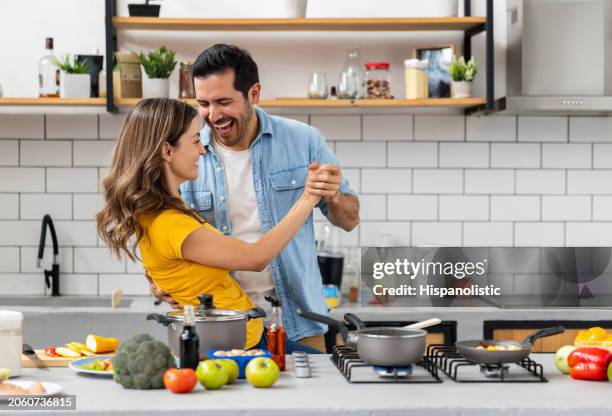 loving couple dancing while cooking together at home - colombia dance stock pictures, royalty-free photos & images