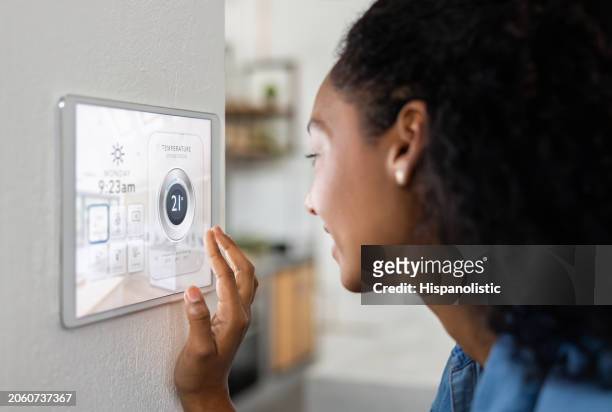 woman leaving her smart home and locking the house using a security system - online search stock pictures, royalty-free photos & images