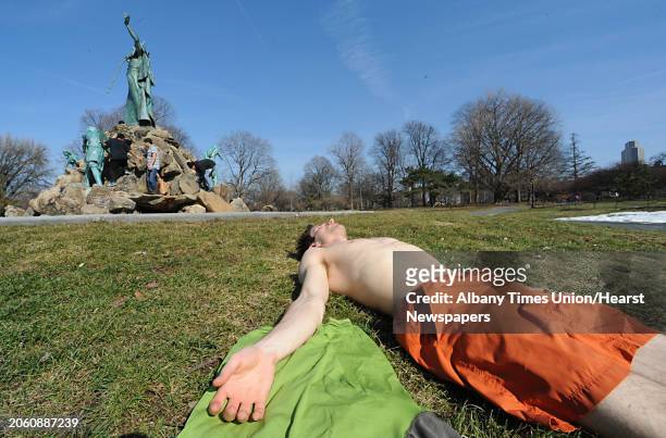 Casey Ambrose, of Albany, tries to get a jump start on his tan in Washington Park in Albany, NY on March 17, 2011.