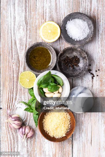 food background with basil, garlic, lemon, seasoning, olive oil, and cheese, ingredients top view - sal de cozinha - fotografias e filmes do acervo