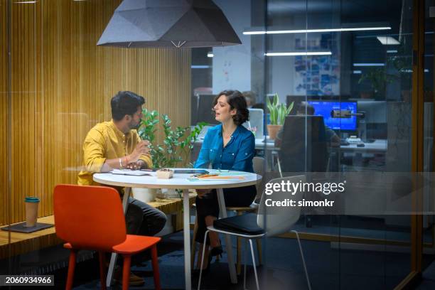homme et femme d’affaires assis dans un bureau - face à face photos et images de collection