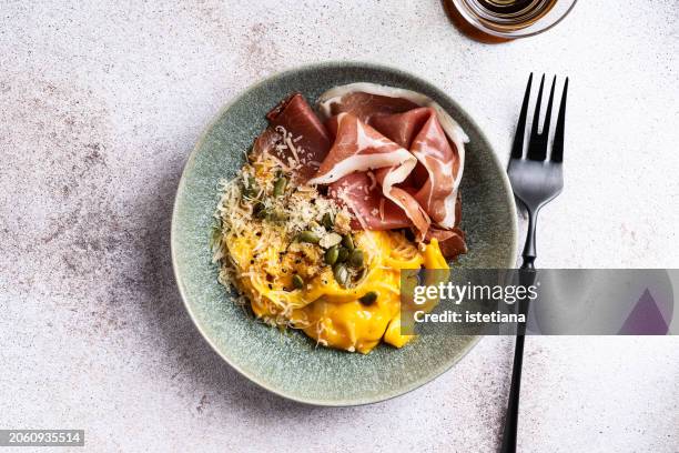 pasta with pumpkin sauce and cured meat, top view - luftgetrockneter schinken stock-fotos und bilder