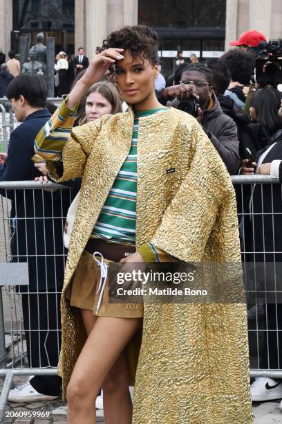 Cindy Bruna is seen wearing a golden Miu Miu coat, a green with white stripes Miu Miu shirt and brown Miu Miu skirt outside the Miu Miu fashion show...