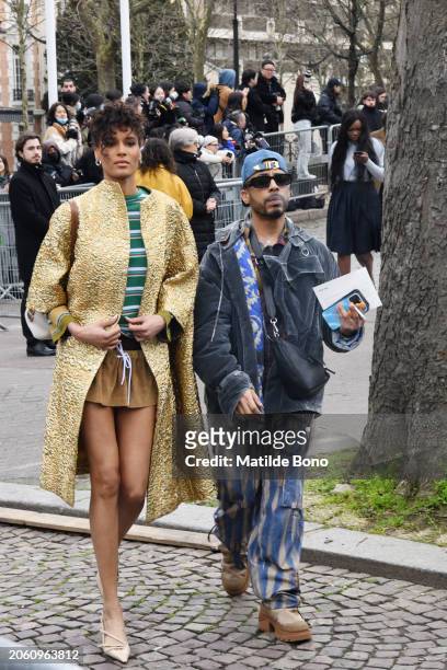 Cindy Bruna is seen wearing a golden Miu Miu coat, a white Miu Miu bag, beige Miu Miu heels, a green with white stripes Miu Miu shirt, brown Miu Miu...