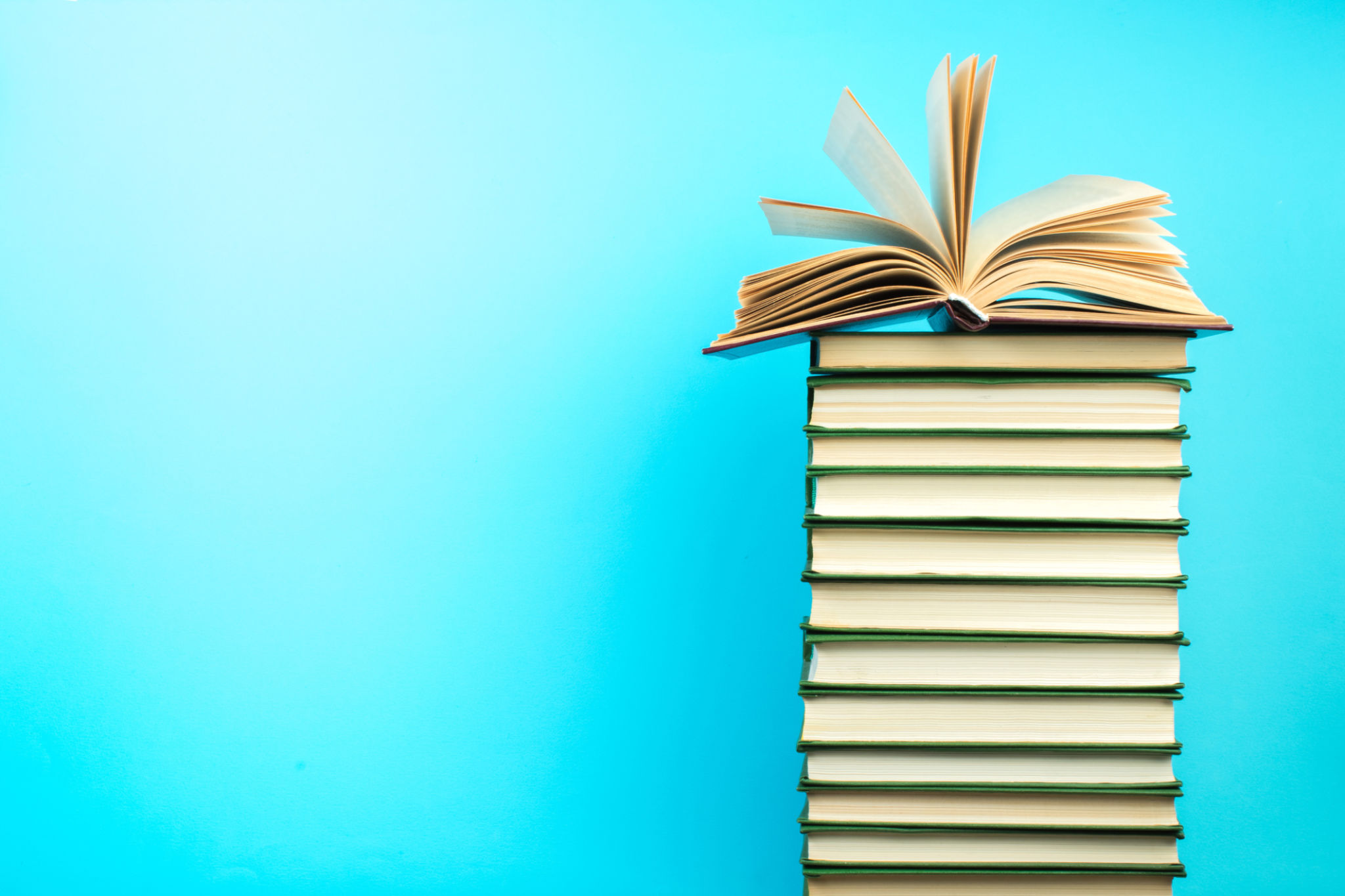 Open book, hardback books on wooden table, on a blue background. Back to school. Copy space for text. Education background. Open book, hardback books on wooden table, on a blue background. Back to school. Copy space for text. Education background.