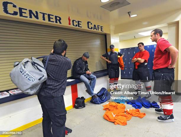 Men are assigned to an orange or blue jersey before an adult men's hockey league game at Albany County Hockey Rink in Albany, N.Y. Wednesday, Oct. 5,...