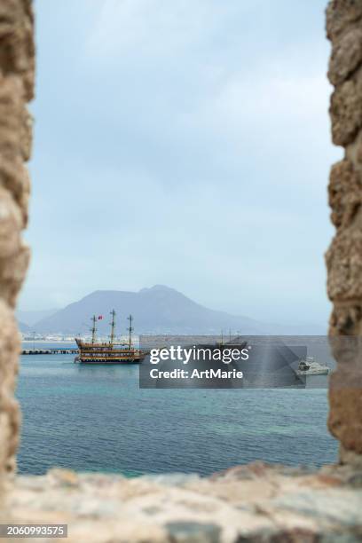 view to the sea and sailing ship through old walls of alanya fortress, turkey - alanya castle stock pictures, royalty-free photos & images