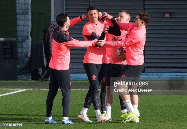 Bernardo Silva, Matheus Nunes, Julian Alvarez and Sergio Gomez of Manchester City joke around during a training session at Manchester City Football...