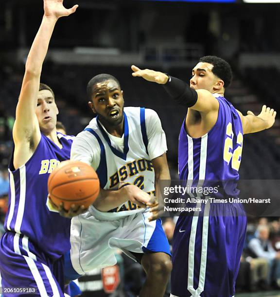 Bishop Maginn's J.R. Briceus is double teamed by CBA's Greig Stire, left, and Nate Robinson as he drives to the basket during a Class AA semifinals...