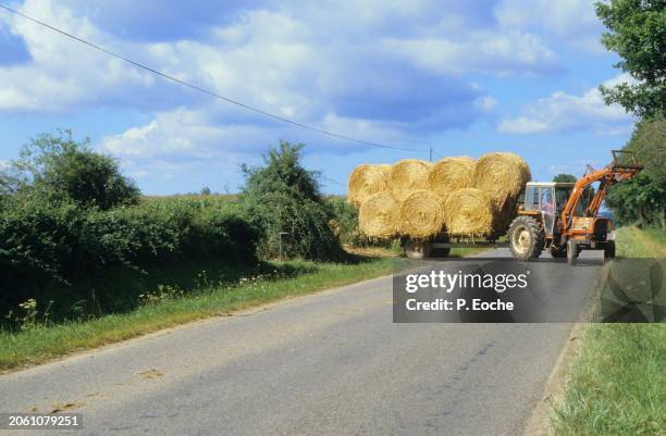 tractor carrying straw bales on a trailer - agriculteur blé stock pictures, royalty-free photos & images