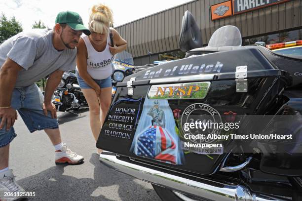 Bill and Mary St. Andrews of Rotterdam read names from the Wall of Honor painted on the back of police motorcycle at Spitzie's Motorcycle Center on...