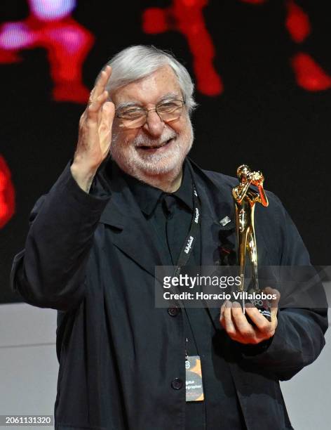 Legendary French photojournalist Jean-Pierre Laffont salutes onstage while holding the award of appreciation given by the Crown Prince, Deputy Ruler...