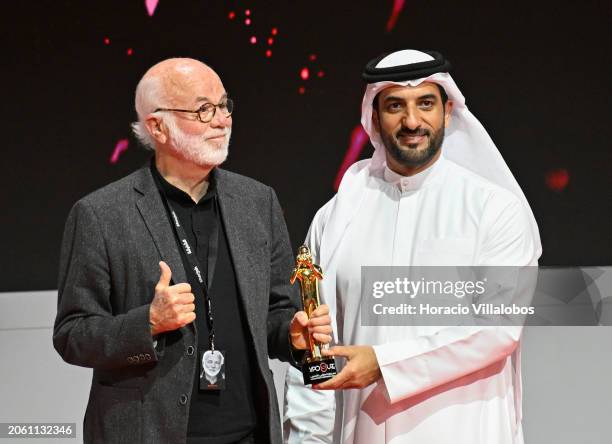 Photojournalist and ex presidential photographer David Hume Kennerly smiles and gives a thumbs-up onstage while holding the award of appreciation...