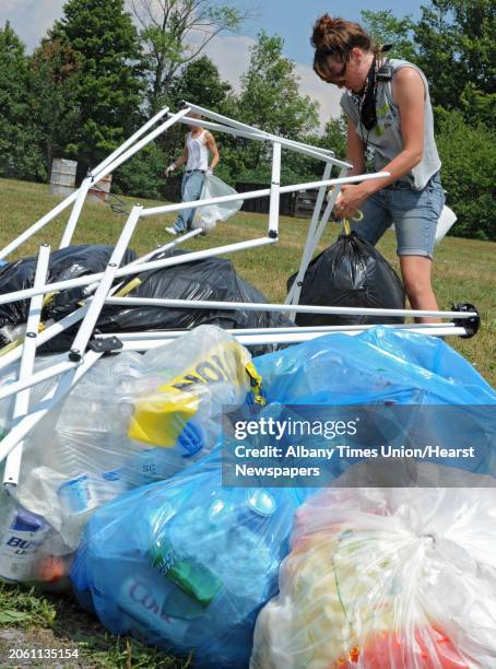 Anna Marie Wright of Boone, N.C. Helps clean up trash left behind from campers who attended the Camp Bisco music festival Monday, July 16, 2012 in...