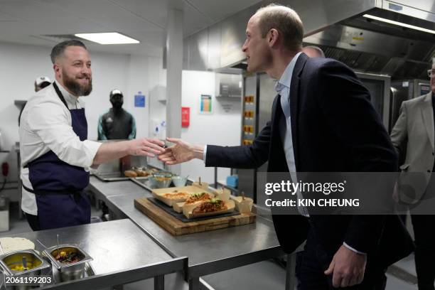 Britain's Prince William, Prince of Wales shakes hands with a chef who has prepared food in seaweed-based food containers during a visit to the Kia...