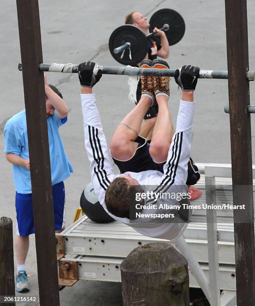 From left, Tom Fitzpatrick of Round Lake wipes sweat off his forehead after carrying a medicine ball 400 meters as Scott Hayes of Broadalbin does...