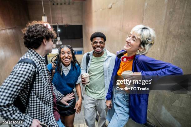 friends talking on the escalator in the subway station - takeaway coffee stock pictures, royalty-free photos & images
