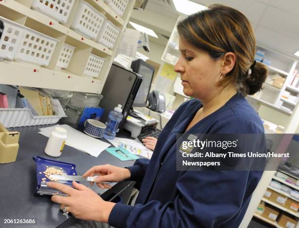 Pharmacist Jamie Robbins counts pills to fill a prescription at Marra's Pharmacy on Friday March 1, 2013 in Cohoes, N.Y.
