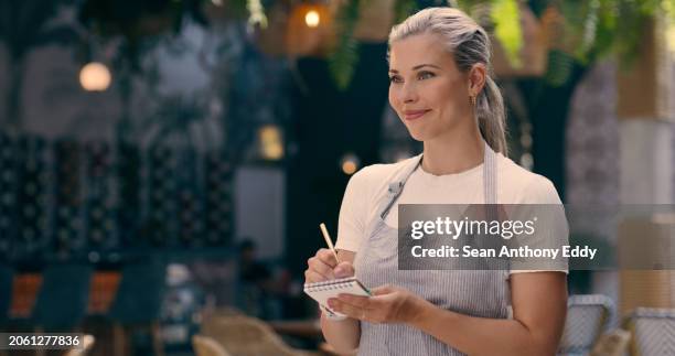waitress, woman and pen with notebook at restaurant for writing order, smile and customer service in london. small business, employee and working with notepad for hospitality, job and food industry - apron mockup stock pictures, royalty-free photos & images