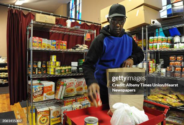 Volunteer Dwight Smith of Albany fills an order at the FOCUS interfaith food pantry in FOCUS Churches of Albany which is housed in Emmanuel Baptist...