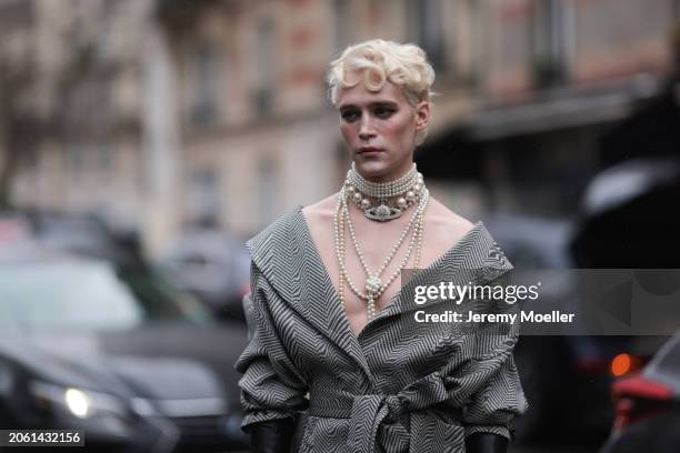 Micah McLaurin is seen wearing a black and grey patterned wool coat with V-neck and bow, black long leather gloves and pearl necklaces by Vivienne...