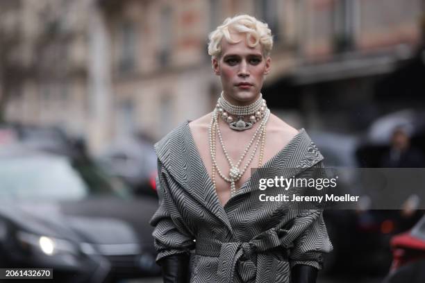 Micah McLaurin is seen wearing a black and grey patterned wool coat with V-neck and bow, black long leather gloves and pearl necklaces by Vivienne...