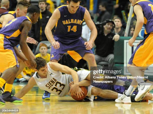 Siena's Rob Poole and UAlbany's Gary Johnson battle for the ball during a basketball game at the Times Union Center Friday, Nov. 8, 2013 in Albany,...