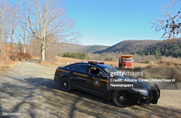 New York State trooper is parked at a road block on Cowdry Hollow Road not too far from a investigation scene on Monday, Nov. 18, 2013 in Berlin,...