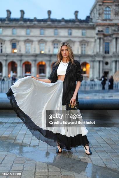 Gu Ailing Eileen wears a black and white striped oversized blazer jacket, a white cropped top, a black and white pleated mesh gathered skirt, shoes,...