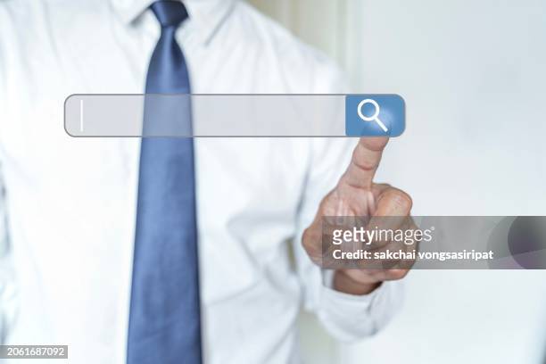 businessman hand touching to search icon bar for search engine optimization of marketing survey concept - help introduction to referencing with wiki markup 1 stock pictures, royalty-free photos & images