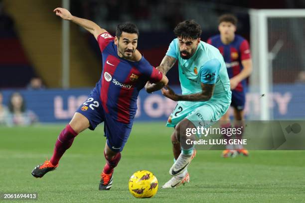 Barcelona's German midfielder Ilkay Gundogan fights for the ball with Real Mallorca's Portuguese midfielder Samu Costa during the Spanish league...