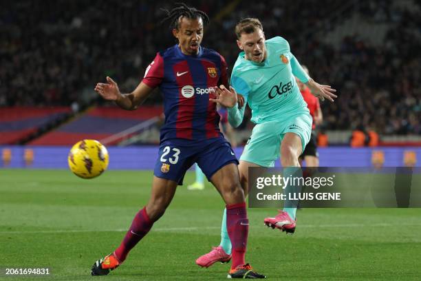 Real Mallorca's Spanish defender Toni Lato fights for the ball with Barcelona's French defender Jules Kounde during the Spanish league football match...