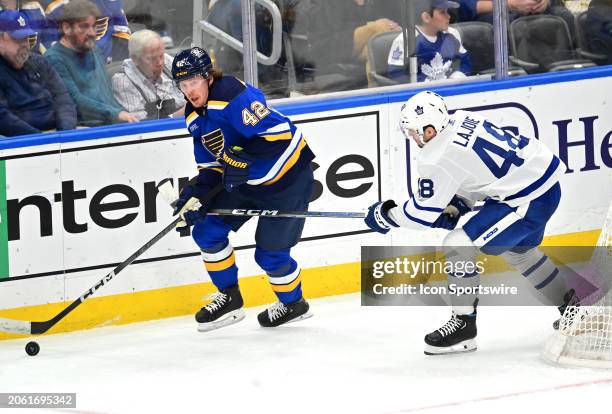 St. Louis Blues right wing Kasperi Kapanen controls the puck ahead of Toronto Maple Leafs defenseman Maxime Lajoie during a NHL game between the...