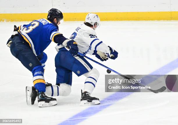 St. Louis Blues right wing Alexey Toropchenko and Toronto Maple Leafs defenseman Jake MdCabe skate after a loose puck during a NHL game between the...