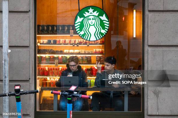 Customers drink and use laptops at the American multinational chain Starbucks Coffee store in Spain.