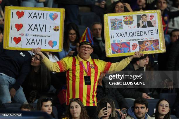 Supporter holds placards reading "I love Xavi" and "Xavi stay" before the Spanish league football match between FC Barcelona and RCD Mallorca at the...