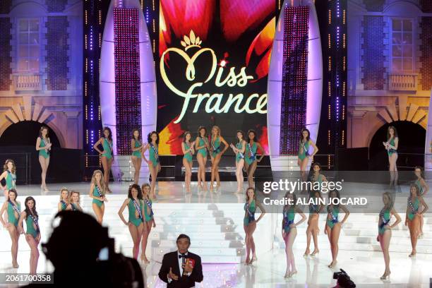 French TV host Jean-Pierre Foucault speaks next to contenders performing during the 62nd Miss France beauty contest, on December 6 2008 in Le...