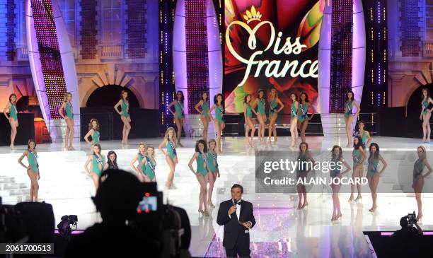 French TV host Jean-Pierre Foucault speaks next to contenders performing during the 62nd Miss France beauty contest, on December 6 2008 in Le...