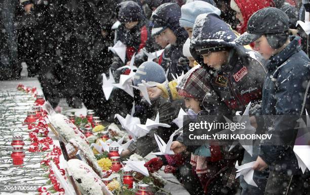 Pupils lay paper doves at the Dubrovka Theatre during a commemoration ceremony in Moscow, 26 October 2005, where Chechen commandos took a hundred...