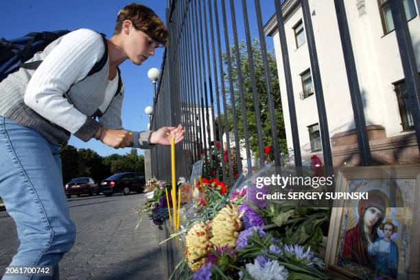 Ukrainian girl lights a candle in front of the Russian embassy in Kiev 06 September 2004 in homage to the some 335 adults and children killed in the...