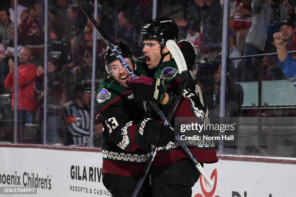 Jack McBain of the Arizona Coyotes celebrates with teammate Michael Carcone after scoring a goal against the Detroit Red Wings during the first...