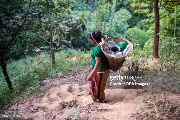 Mro woman goes to fetch drinking water from a mountain spring. Mro people are an indigenous ethnic group in Bangladesh. They primarily inhabit the...