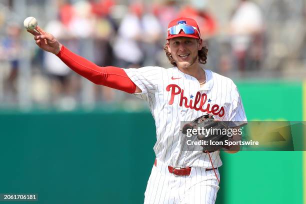 Philadelphia Phillies third baseman Alec Bohm throws the ball over to first base during the spring training game between the Houston Astros and the...