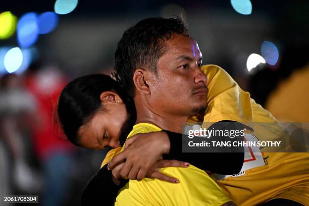 Man carries a woman during a competition and Guinness World Record attempt in Phnom Penh on March 8, 2024. Hundreds of Cambodian couples braved...