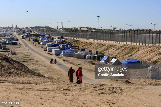 Palestinian people walk among the makeshift tents set up near the border of Egypt as Israeli attacks continue on March 08 in Rafah, Gaza. Thousands...