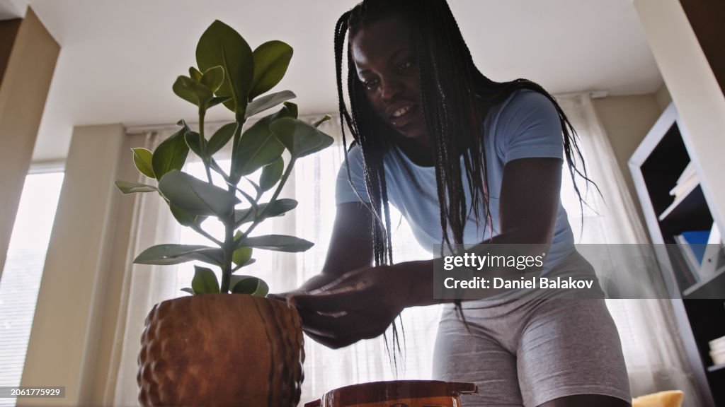 Black woman doing home gardening vlog at home.