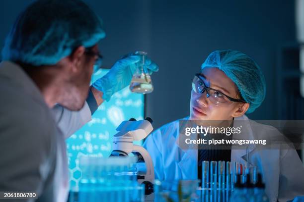 consultant scientists are gathering and brainstorming ideas on the results of experiments with liquid chemical components in the science laboratory. - lubricación fotografías e imágenes de stock